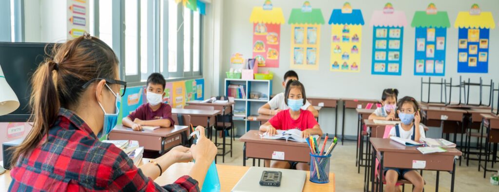 Teacher showing class how to use hand sanitizer