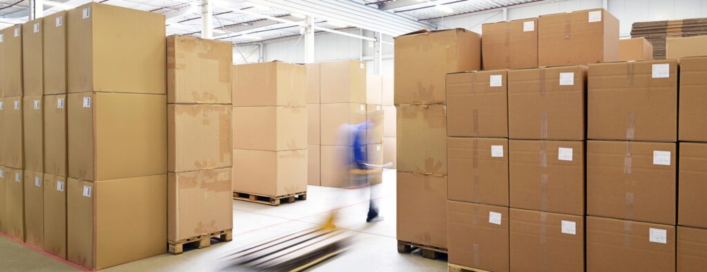warehouse full of boxes and blurred worker walking by