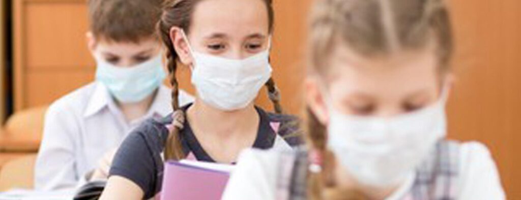 young students wearing face masks inside a classroom